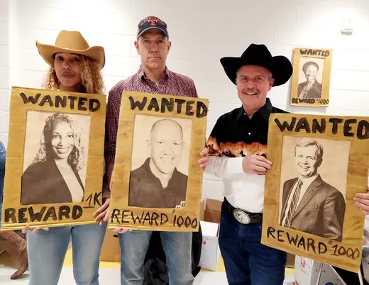 Holding their Wanted posters