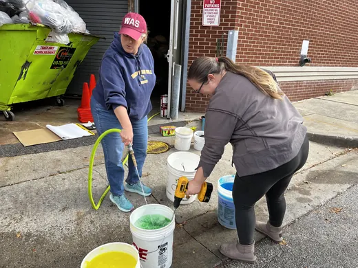 Mixing buckets of slime behind the school