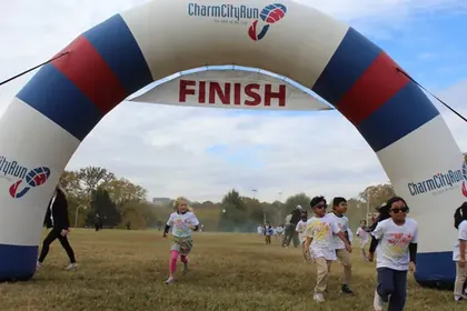 Runners coming through the finish arch at BeeFit